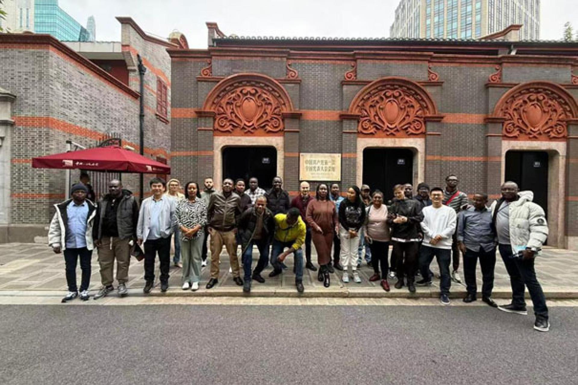 Des journalistes qui posent devant la maison ayant arbitré le premier congrès du PCC. Photo fda